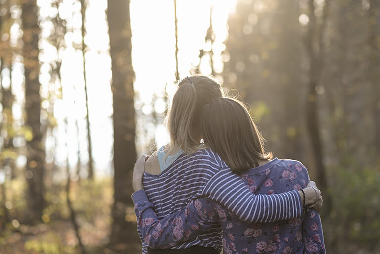 girls hugging in forest